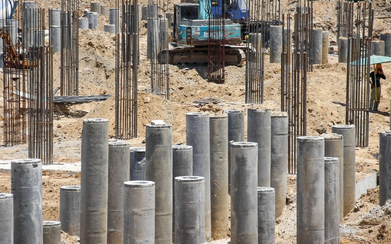 Heavy machinery driving piles into the ground at a construction site