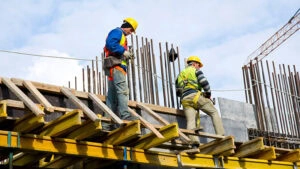Workers examining construction work at a site, surrounded by various equipment and machinery.