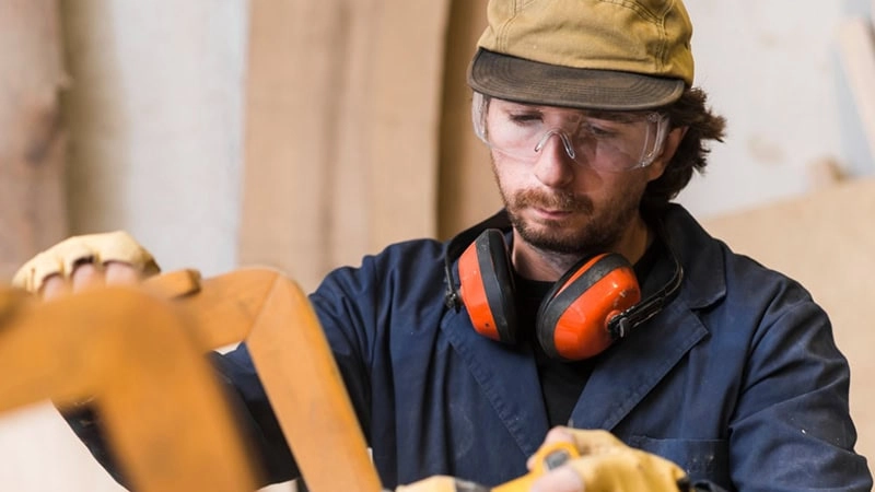 A worker inspecting wear signs in tools at a construction zone