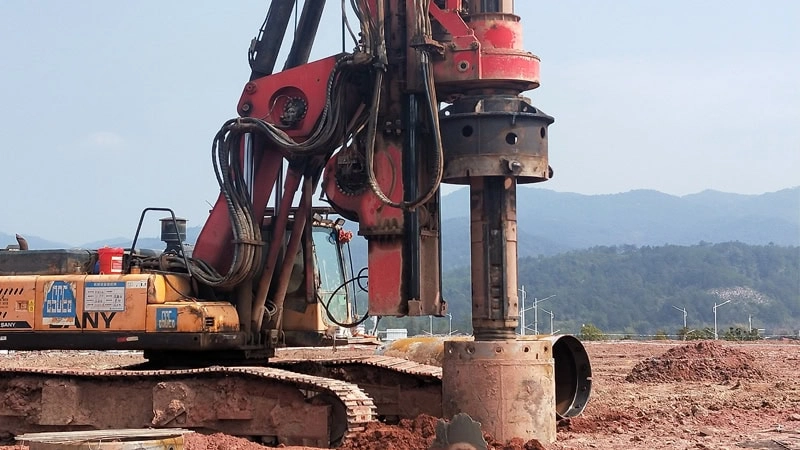 The rotary drilling rig is using the drill barrel to drill holes on the ground